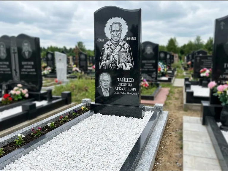 Памятник с гравировкой иконы: стела с крестообразным навершием — икона в резной рамке-киоте, газон без ограды, стриженая трава, работа «Раевская» в Калининграде