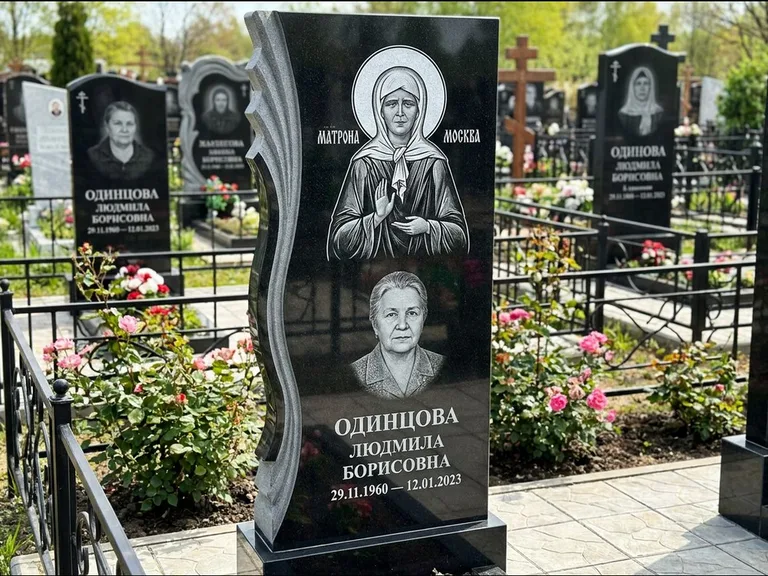 Памятник с гравировкой иконы: ступенчатая двухуровневая стела — Архангел Михаил на стеле, каменная дорожка из плитняка, работа «Одинцов» в Калининграде