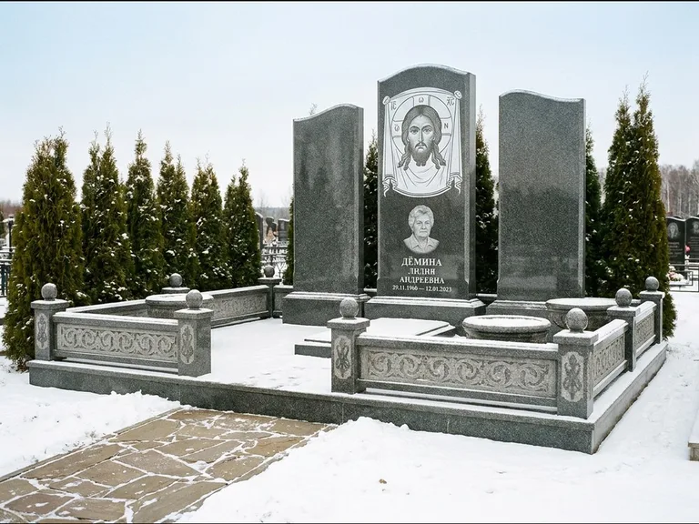 Памятник с гравировкой иконы: узкая вертикальная стела-пилон с ликом — икона в резной рамке-киоте, открытая лужайка без ограды, работа «Одинцов» в Калининграде