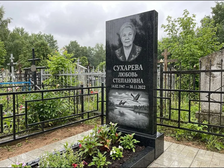 Памятник с гравировкой журавлей — гравировка пары журавлей над гладью озера в нижней части, работа «Сухарева» в Калининграде